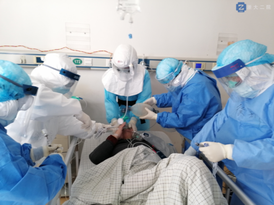 李立斌主任（中）戴著正壓頭套，為新冠肺炎危重癥病人